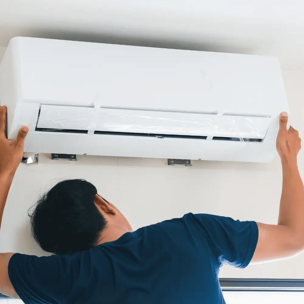 HVAC installer fitting white wall-mounted air conditioning unit.